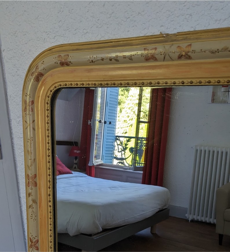 Un beau cadre doré parfait la décoration d'une des chambres, sous le ciel bleu d'Auvergne